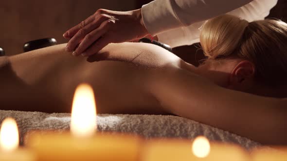 Young, healthy and beautiful woman gets massage therapy in the spa salon. alt