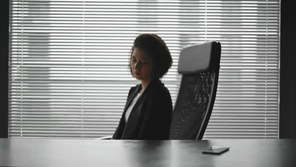 Silhouette of Tired Business Lady in Ofiice Behind the Desk alt