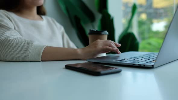 Closeup a woman working and touching on laptop computer touchpad in office