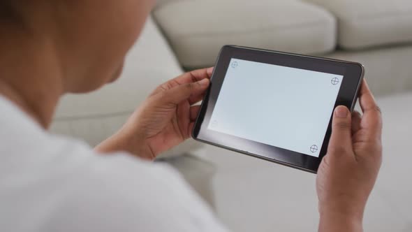 African american senior woman sitting on couch using tablet, with copy space on screen alt