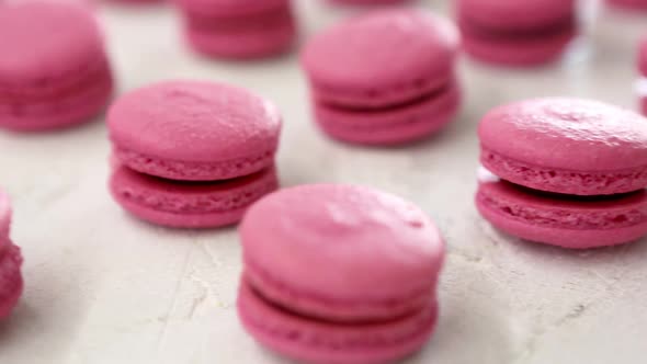 Closeup View of Many Rows of Pink Macarons Macaroon on White Background alt