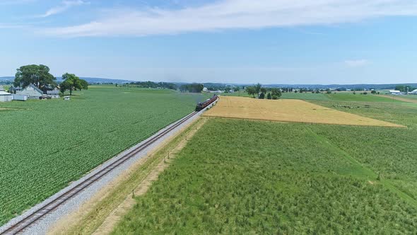 Aerial View of a Steam Engine Puffing Smoke and Steam with Passenger Coaches Traveling alt