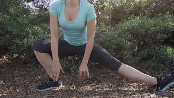 A young woman runner stretching before her run. alt