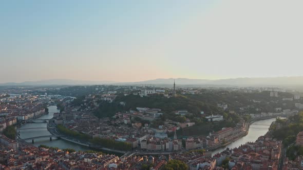 Cinematic circling drone shot of Lyon Basilica and river Rhone Saone at sunset alt
