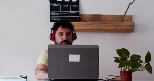 Spanish Man Working Happily at Home with a Computer  alt