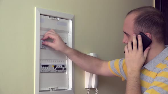 Man Consults By Phone on Electrical Fault in Own Room