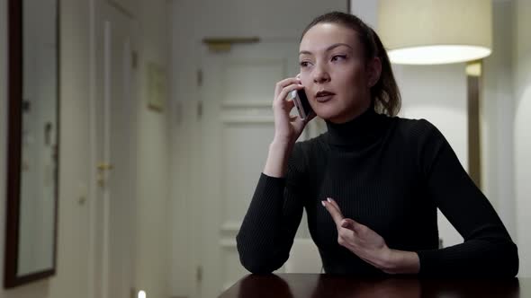 Furious Woman Is Talking By Cellphone Sitting at Home Alone Swearing on Phone alt