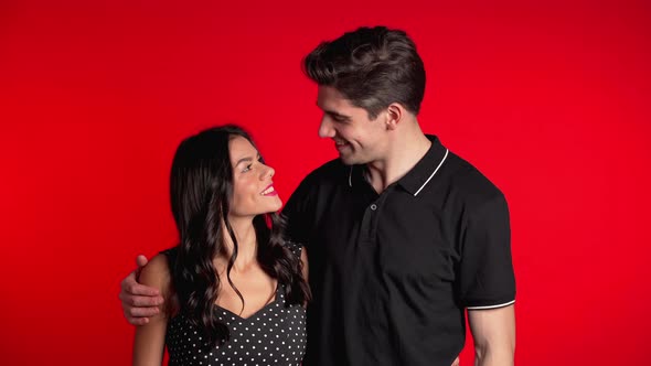 Portrait of Young Couple on Red Studio Background. Love Concept. alt