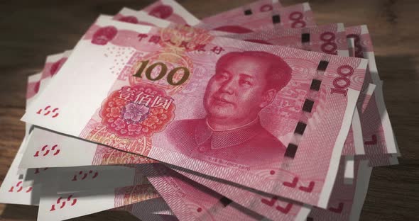 China Yuan 100 money banknotes falling on the table