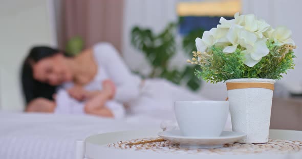 Beautiful Young Woman Lies with a Baby on the Bed and Plays a Loving Mother alt