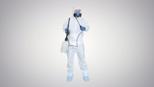 Man Wearing an NBC Personal Protective Equipment (Ppe) Suit Spraying Disinfectant Water To Remove alt