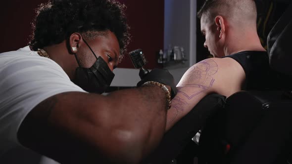 Cinematic Shot of a Tattoo Artist Creating Body Art at the Tattoo Studio alt