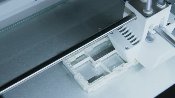 Camera Pan Across 3d Printer Printing Plastic Building Model in Architects Office alt