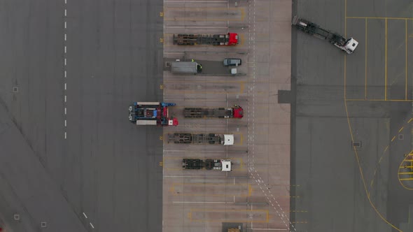 Overhead Top Down Aerial View of a Forklift Moving Cargo From Parked Truck in Cargo Terminal Seaport alt
