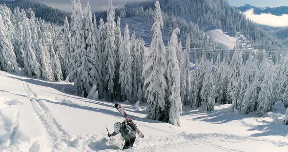 Male Skier Hiking Trail In Mountainous Snow Covered Backcountry - Aerial Drone View alt