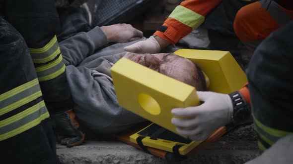 Rescuers Fixating Head of Injured Man alt