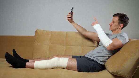 Young Man with Injured Knee and Forearm Takes Selfies, Stock Footage