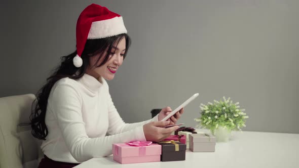 happy woman in santa hat shopping online for Christmas gift with digital tablet