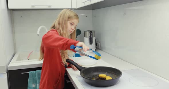 A Girl Cooks Food in the Kitchen