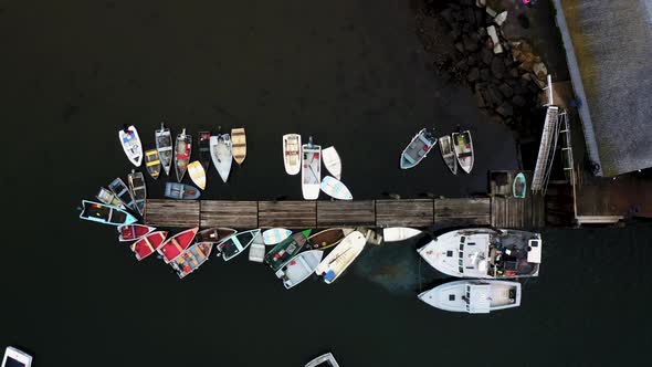 drone aerial lift shot of dock with small boats and lobster fishing vessel 4k 30p alt