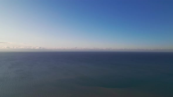 Calm sea and blue sky with light clouds. Beautiful sea, ocean background, aerial view.