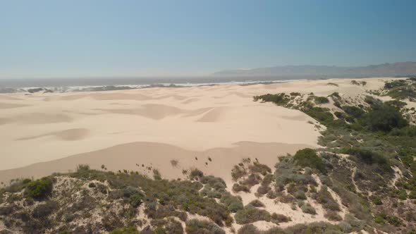 Drone flies over unique large sand dunes near Pismo Beach