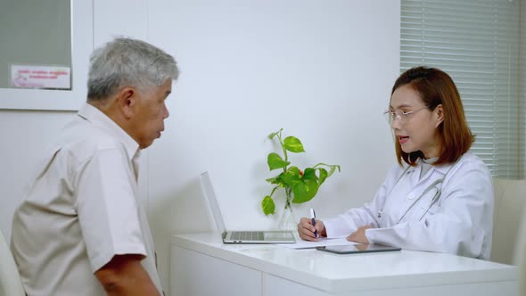 Asian female doctor interrogates an elderly man in a hospital office.health care concept