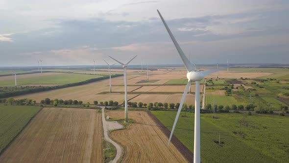 Aerial view of wind turbine generators in field producing clean ecological electricity. alt