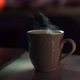 A Brewed Drink with Boiling Water in a Ceramic Cup Against Blurred Backdrop