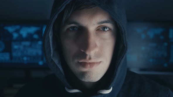 Close Up Portrait of Hacker Programmer in Black Hoody at Background of Cyber Security Center Filled alt