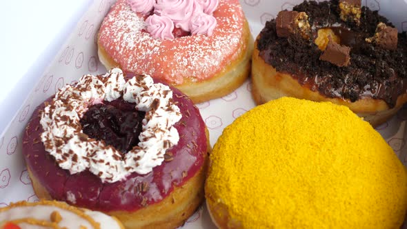 Close Up of Various Plant Based Beautiful Colourful Dughnuts alt