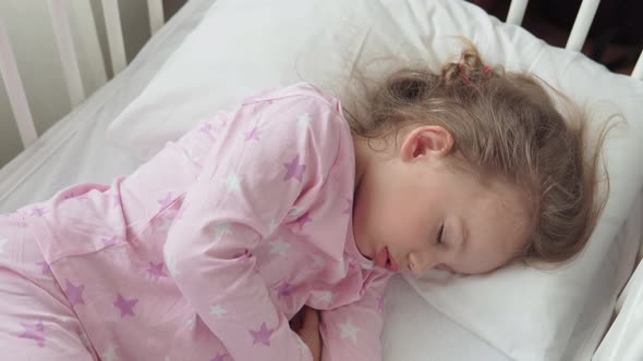 Close Up Authentic Cute Caucasian Little Preschool Child Girl Sleep Sweetly in White Crib on Pajama