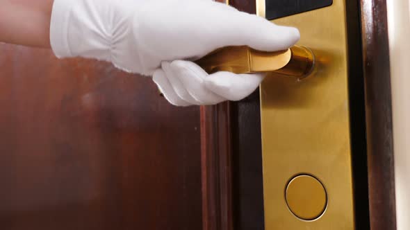 Cleaning and Hotel Concept. Close-up Shot of Maid in Gloves Opening Door Handle and Then Entering alt