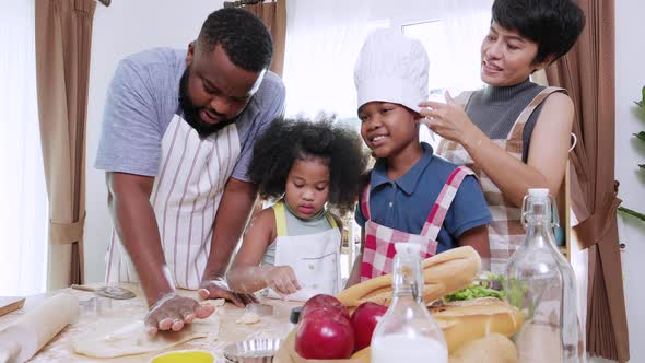 African America family mixing flour, eggs, and milk for holiday