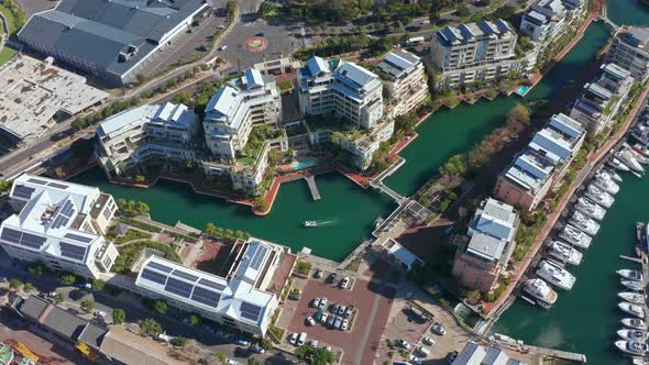 Aerial shot tilting down onto the marina canal with a boat speeding across it