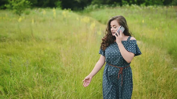 Confident and Smiling Young Caucasian Woman Holding Phone During Walking Talking with Best Friend on