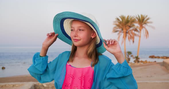 Portrait of Happy Teen Girl in Hat on Tropical Beach Looking Around Herself