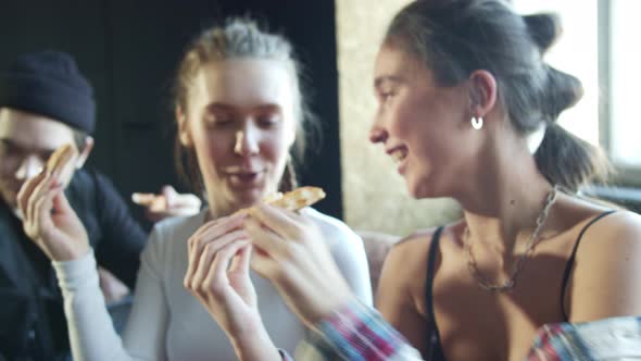 Teenagers are Eating Delicious Pizza Sitting Close to Each Other alt