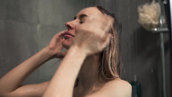 Young Blonde Woman Washing Her Hair in the Shower alt