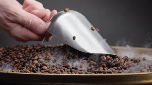 Man Hand Holding Ladle Scooping Coffee Seeds Close Up alt