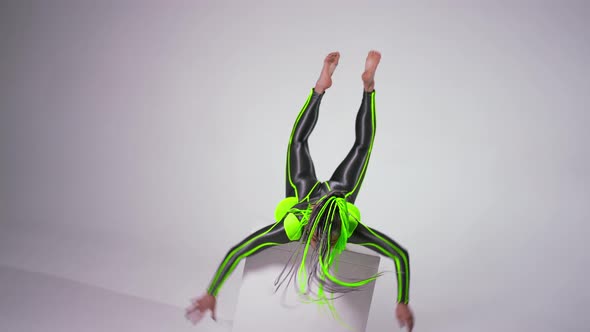 Angle View of Confident Dancer Rolling Over Cube in Slow Motion and Looking at Camera alt