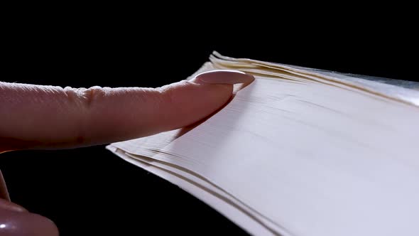 The Girl Runs Her Fingernail Over the Pages of a Thick Book Flipping Through Them in Slow Motion alt