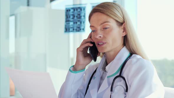Adult Female Doctor Reading a Prescription for Treating Patient in Clinic alt