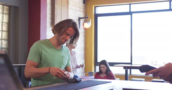 Man giving his credit card to a bartender alt