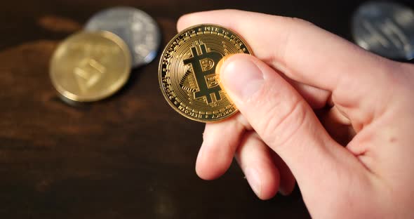 A man holding a digital cryptocurrency bitcoin as he thinks about a secure, decentralized economy an alt