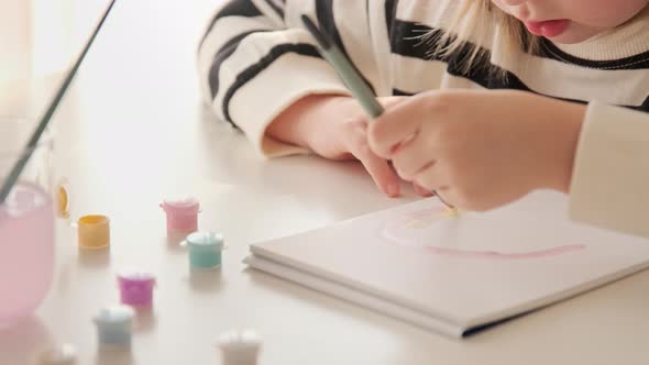 Little kid girl artist drawing coloring picture with paints and brushes. Child hobby alt