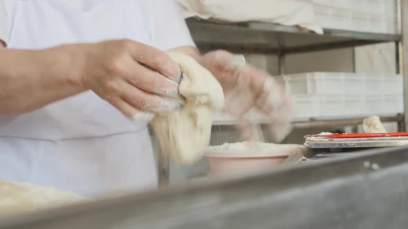 the Female Hands of the Baker Form a Round Bun From the Dough for Baking in the Oven alt