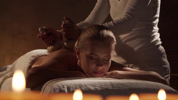 Young, healthy and beautiful woman gets massage therapy in the spa salon. alt