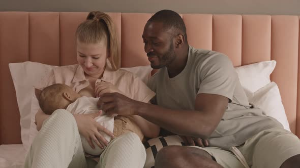 Man Watching Wife Breastfeeding Child alt