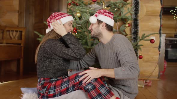 Couple with Christmas hats kissing alt